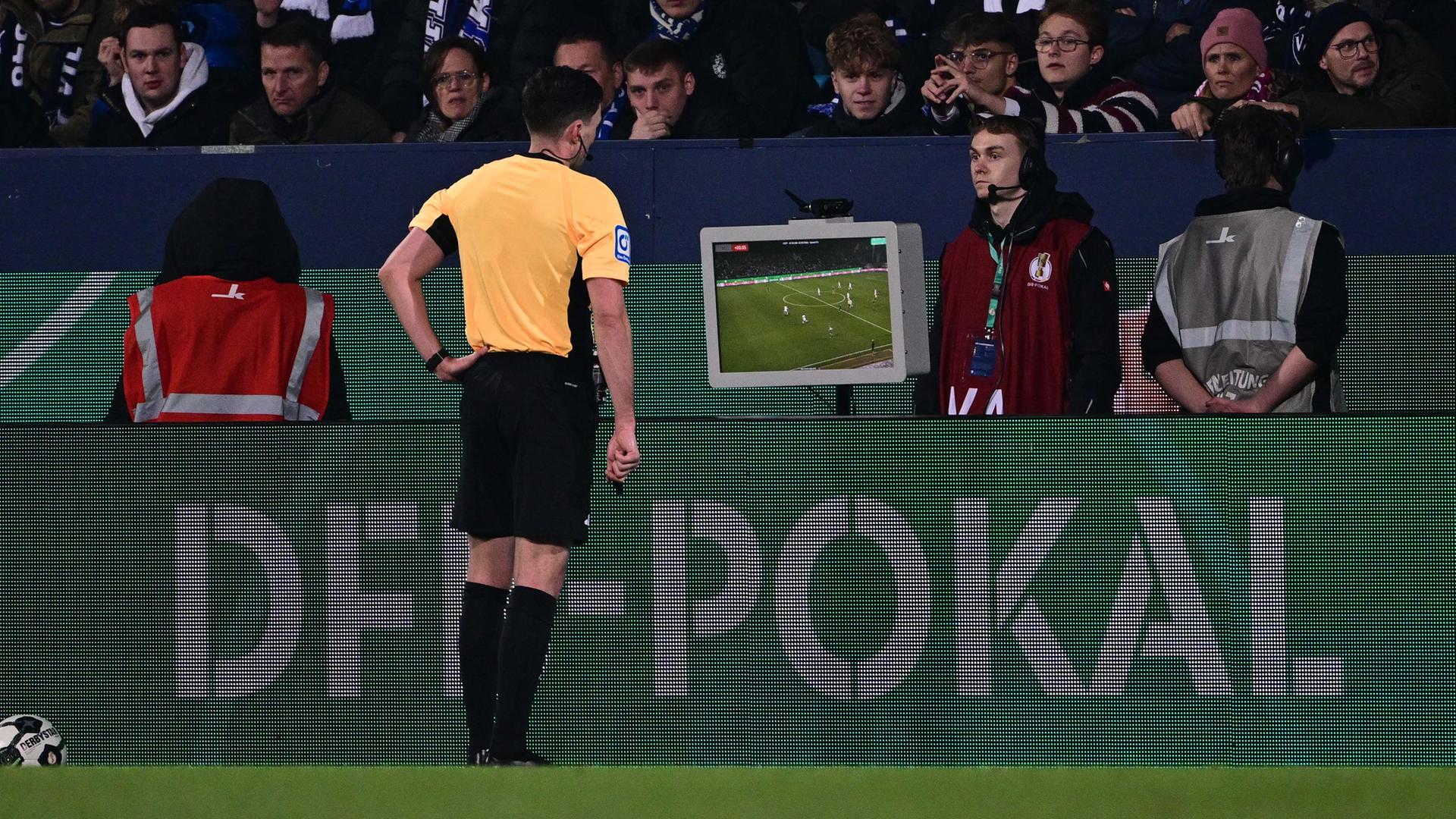 Der deutsche Schiedsrichter Florian Badstübner sieht sich im Achtelfinale des DFB-Pokal zwischen dem VfL Bochum und VfB Stuttgart eine Szene im VR-Kasten an