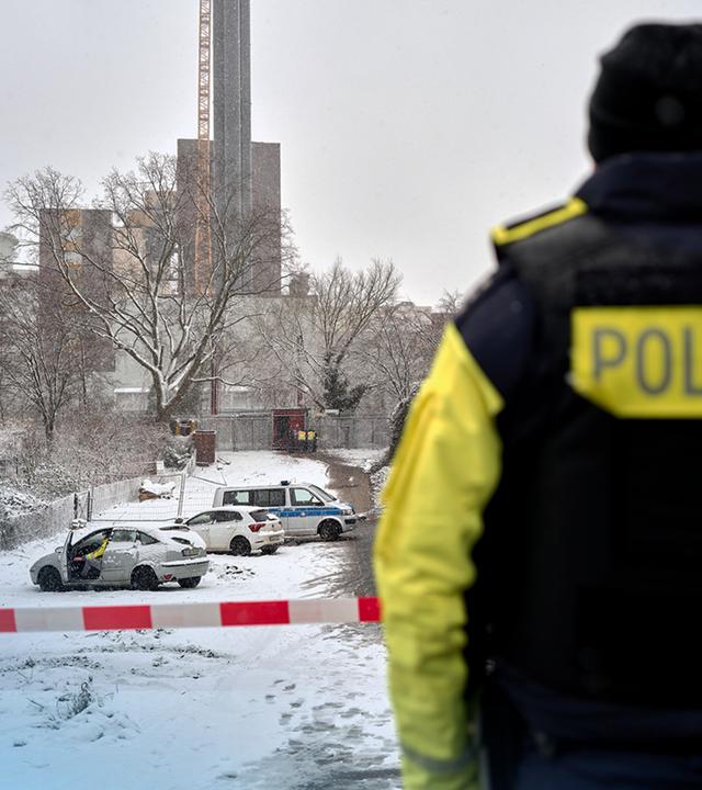 Tatort des Brandanschlags auf die Energieversorgung in Berlin mit einem Ermittler der Polizei im Vordergrund.