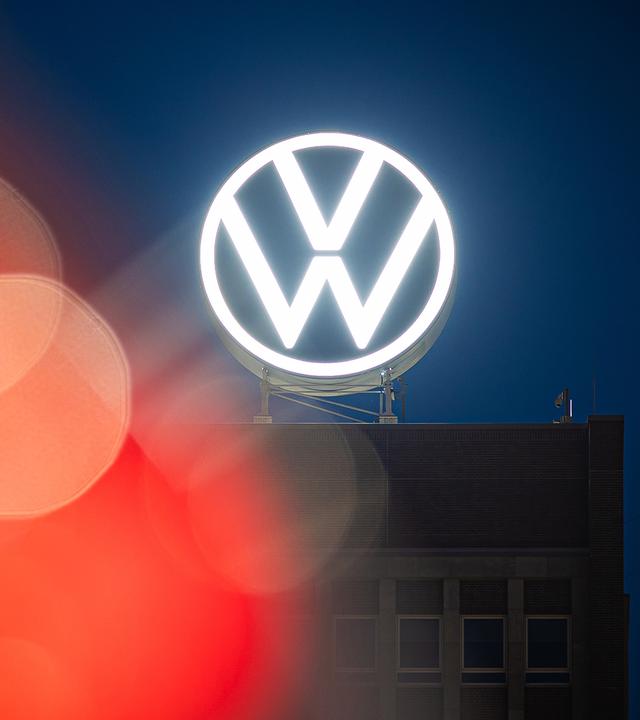 Das VW-Logo leuchtet auf dem Dach des Markenhochhauses im Volkswagen Stammwerk (Archivfoto)
