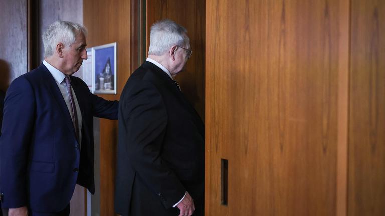 Zwei Männer betreten einen Raum