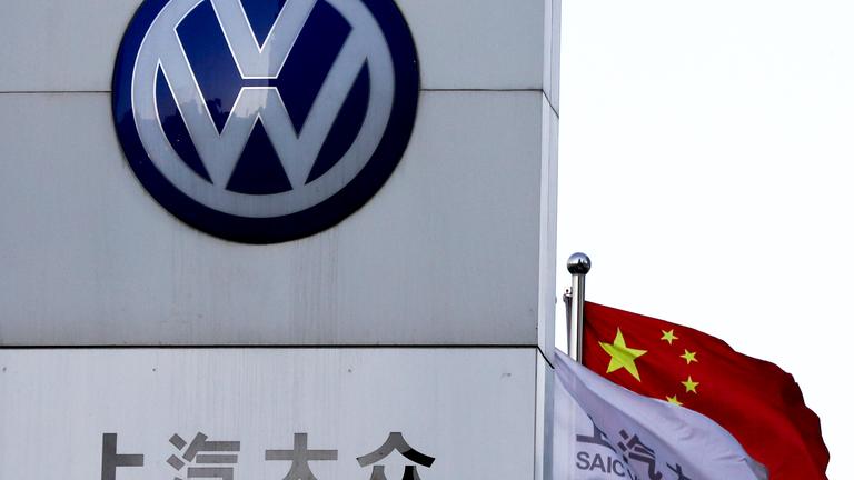 eine chinesische fahne weht neben einer vertretung von saic volkswagen. 