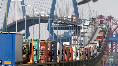 Symbolbild: mit containern beladene lastwagen stauen sich auf der koehlbrandbruecke in hamburg