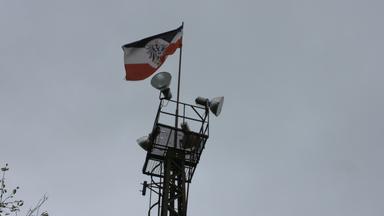 Turm mit Lautsprechern und Reichskriegsflagge