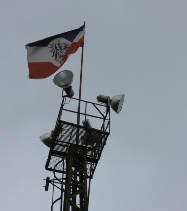 Turm mit Lautsprechern und Reichskriegsflagge