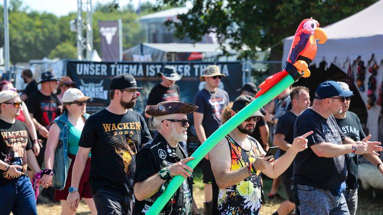 Metal Fans auf dem Weg über das Festival-Gelände beim Wacken Open Air.