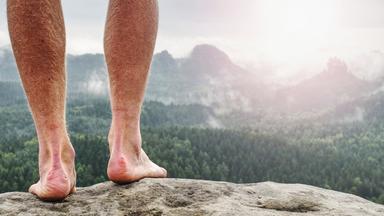 Der Mensch nimmt eine Pause in der Natur und schaut vom Gipfel hinunter