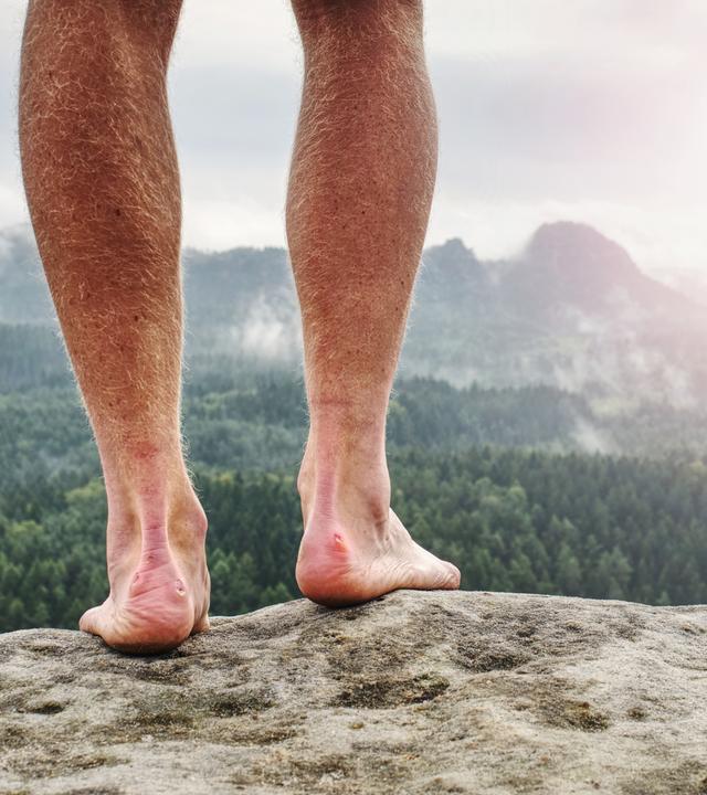 Der Mensch nimmt eine Pause in der Natur und schaut vom Gipfel hinunter