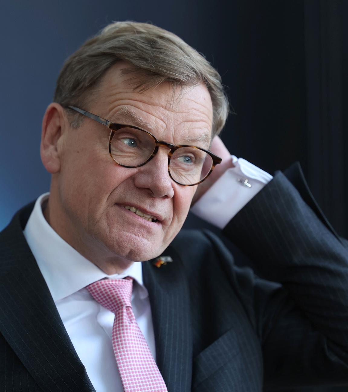 Johann Wadephul, eine Hand an der linken Seite des Kopfes.