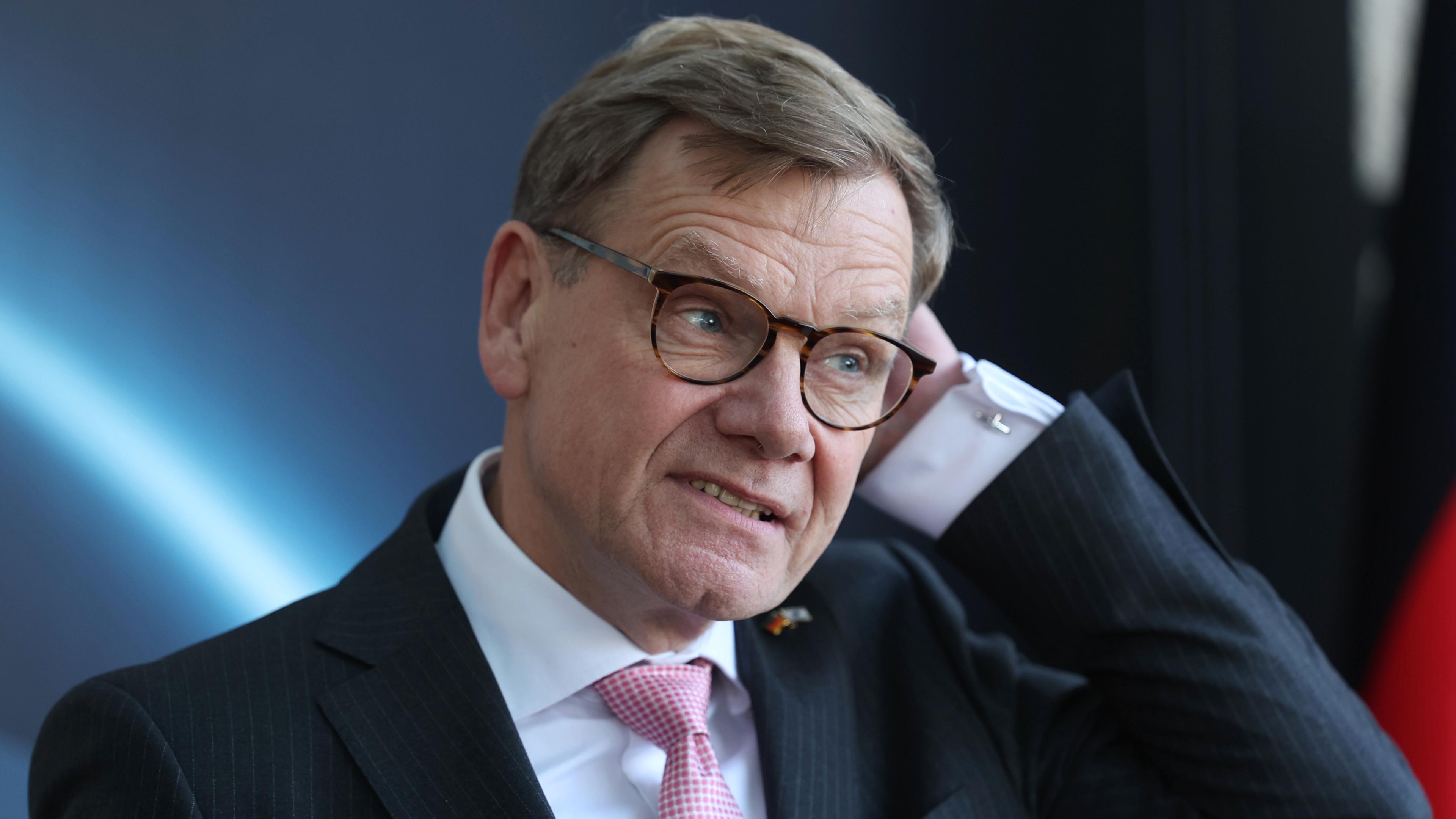 Johann Wadephul, eine Hand an der linken Seite des Kopfes.