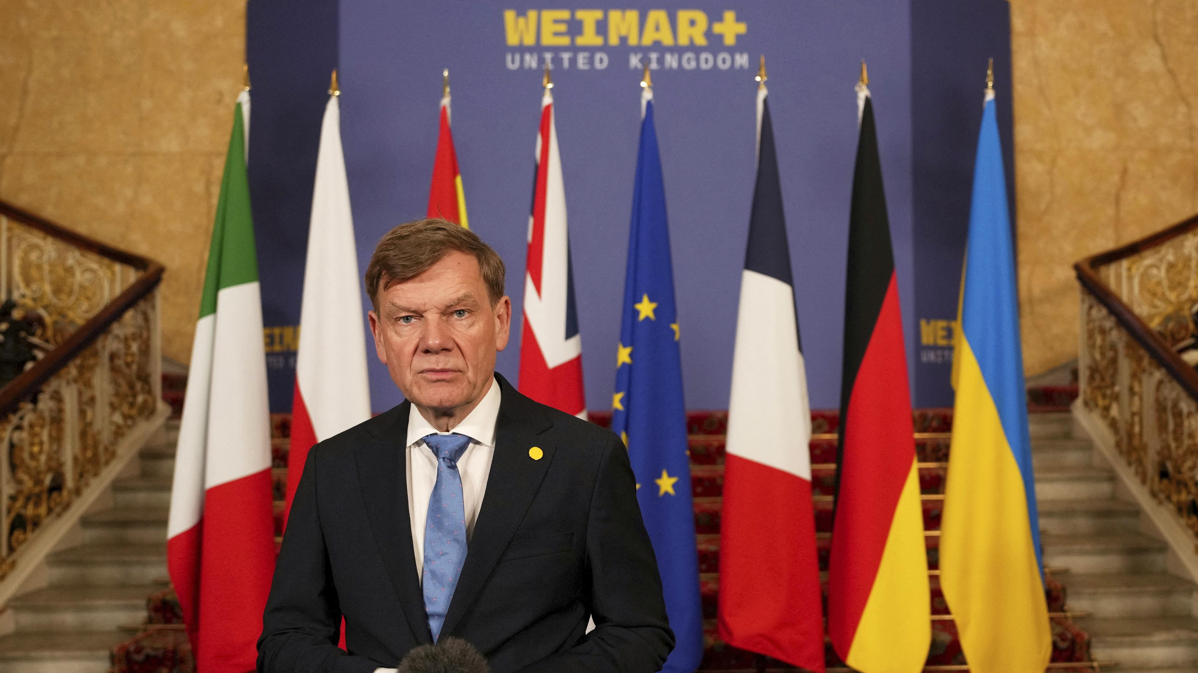 Außenminister Wadephul steht vor Flaggen bei einer Ukraine-Konferenz in London.