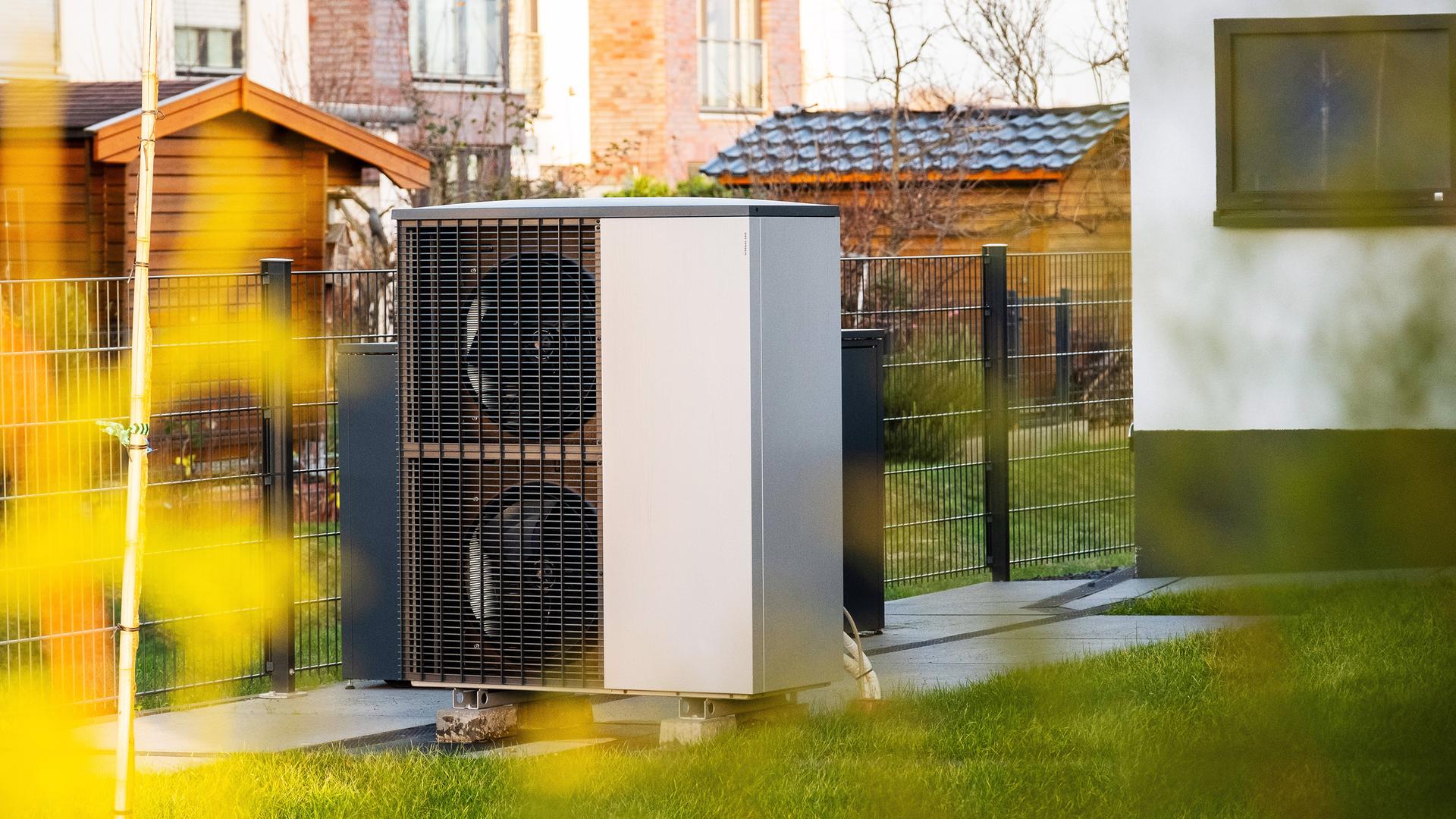 Eine Wärmepumpe vor einem Mehrfamilienhaus in Düsseldorf, aufgenommen am 30.12.2023