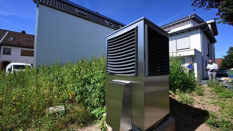 Baden-Württemberg, Plankstadt: Vor einem neu gebauten Wohngebäude ist im Garten eine Wärmepumpe zum Heizen des Gebäudes in Betrieb.