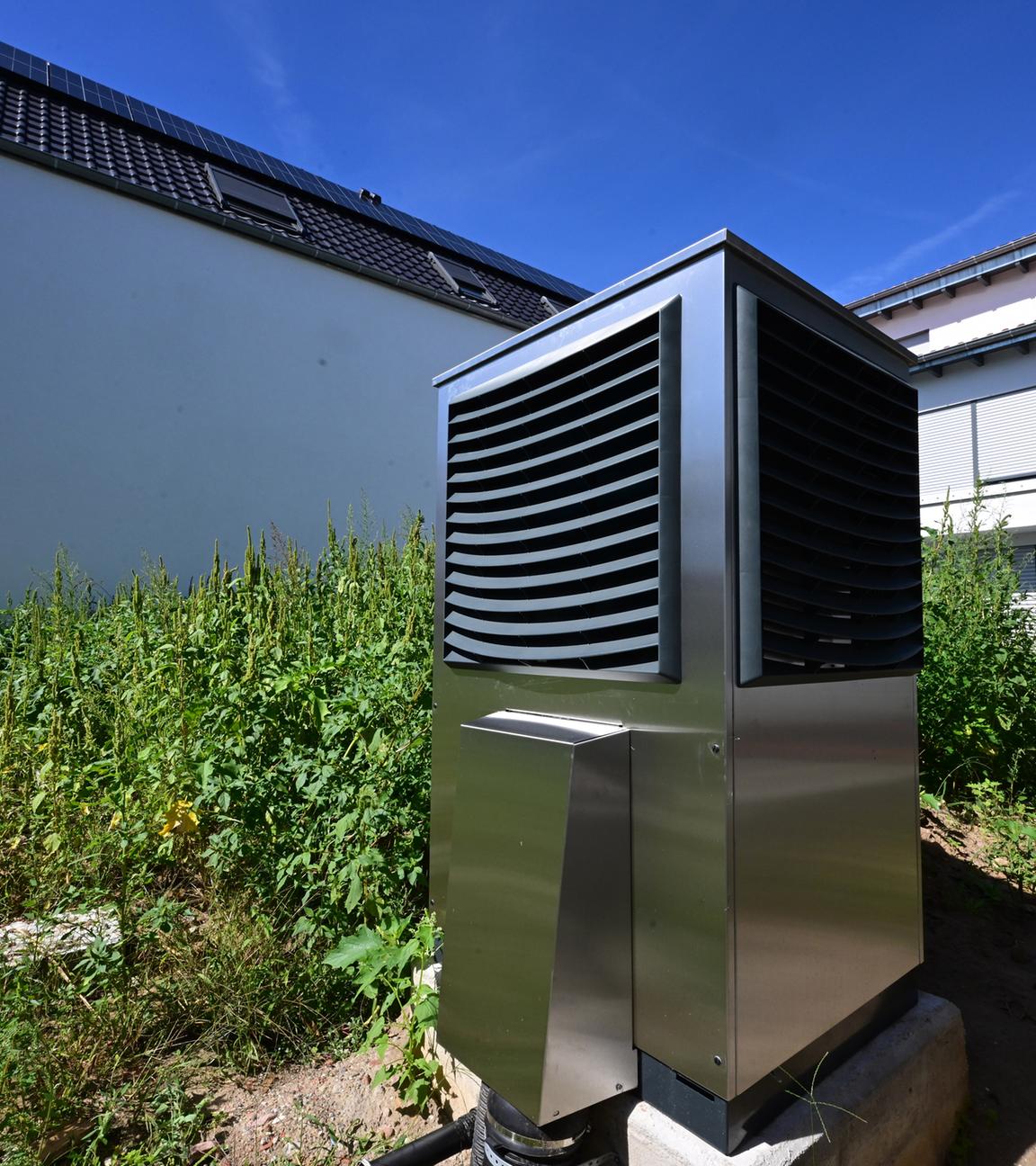 Baden-Württemberg, Plankstadt: Vor einem neu gebauten Wohngebäude ist im Garten eine Wärmepumpe zum Heizen des Gebäudes in Betrieb.