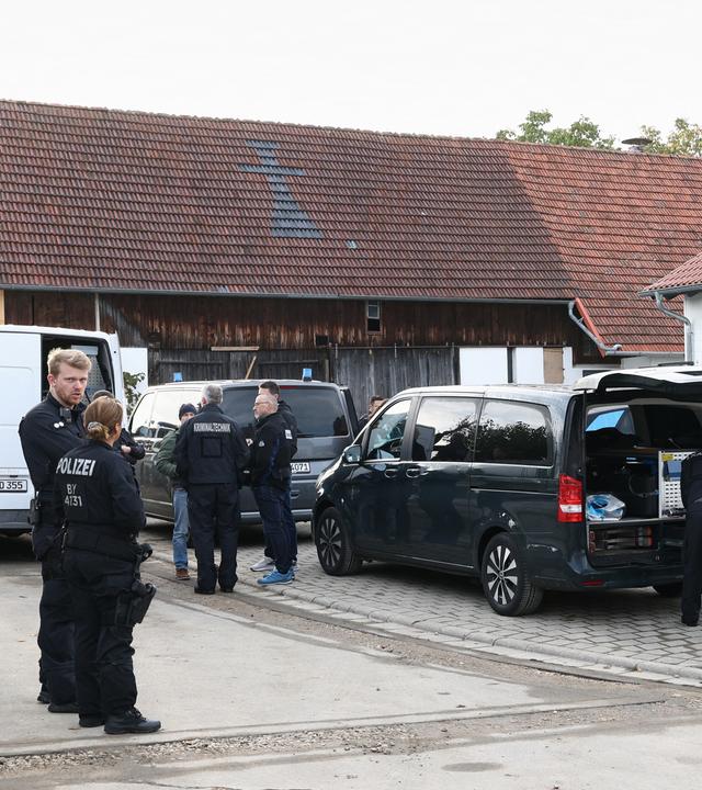 Polizisten und Kriminaltechniker stehen vor einem Tatort.