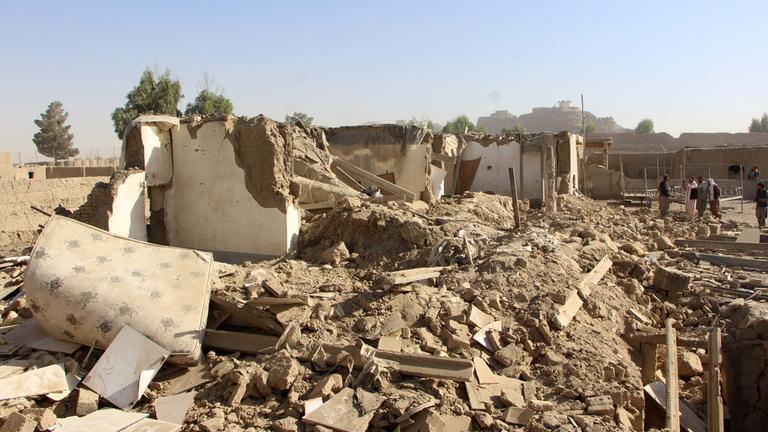 Menschen stehen neben den Trümmern eines Gebäudes in Spin Boldak, Afghanistan.