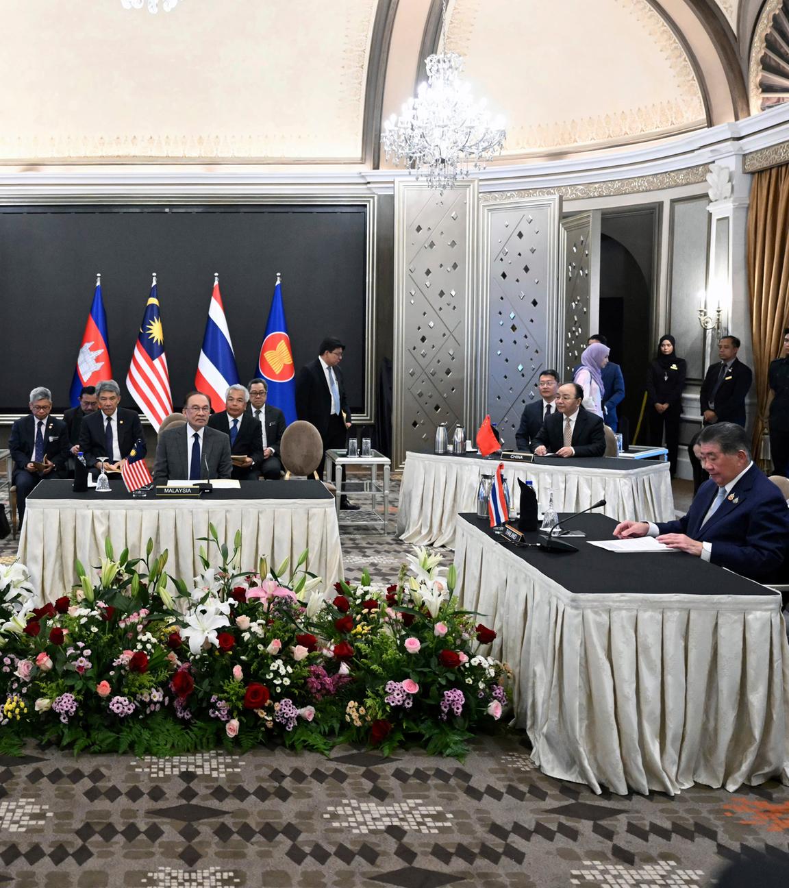 28.07.2025, Malaysia, Putrajaya: Der malaysische Ministerpräsident Anwar Ibrahim (M) sieht zu, wie der kambodschanische Ministerpräsident Hun Manet (l) und der amtierende thailändische Ministerpräsident Phumtham Wechayachai (r) an Gesprächen über einen möglichen Waffenstillstand zwischen Thailand und Kambodscha teilnehmen. 