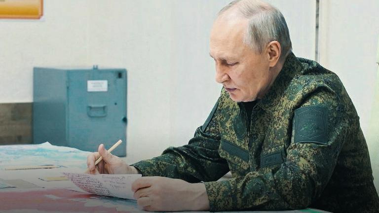Putin in Militäruniform an einem Tisch, über ein Dokument getauscht
