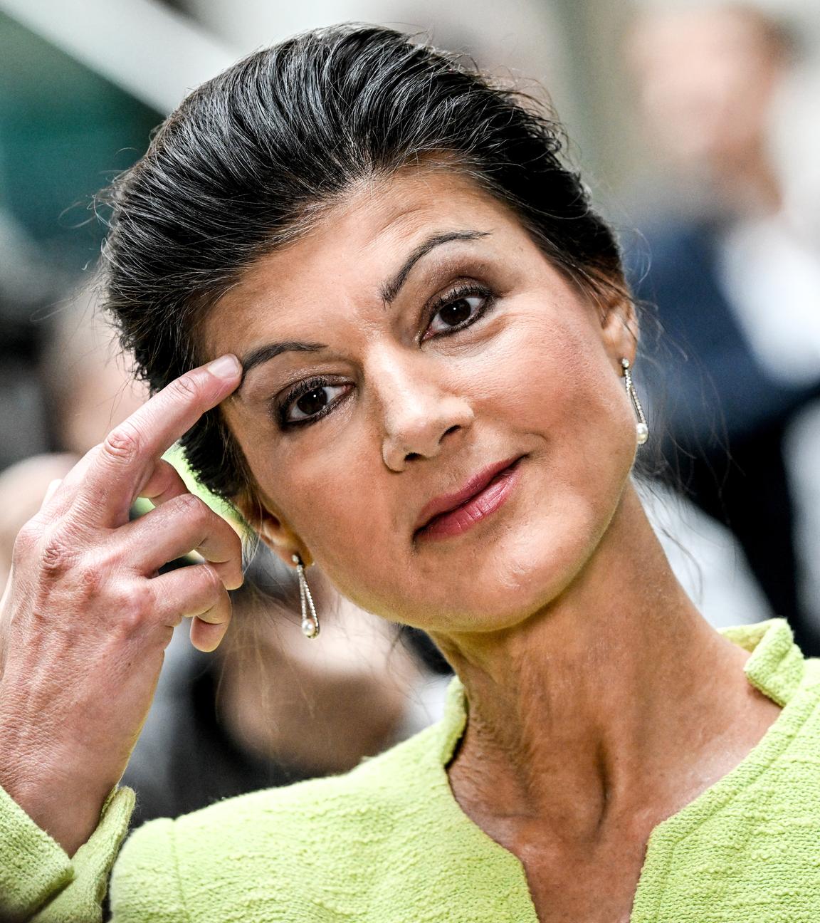 Sahra Wagenknecht kratzt sich an ihrer rechten Augenbraue.