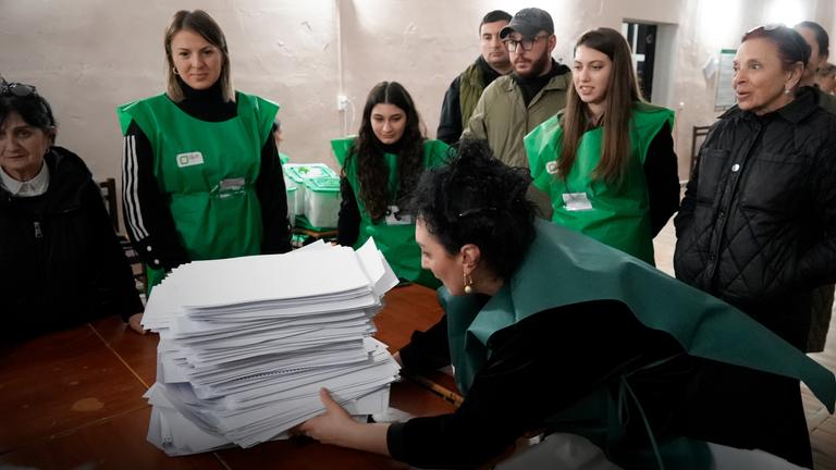 Mitglieder einer Wahlkommission bereiten sich auf die Auszählung der Stimmzettel in einem Wahllokal nach der Parlamentswahl in Tiflis (Georgien), aufgenommen am 26.10.2024 