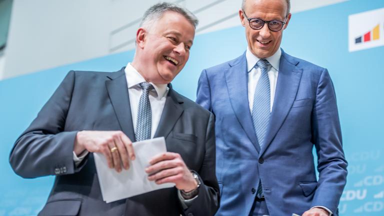 Bundeskanzler Friedrich Merz geht neben Gordon Schnieder in der Parteizentrale.