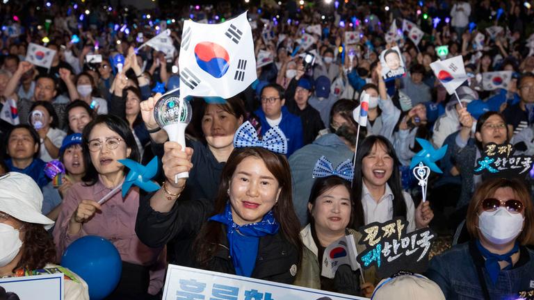 Südkoreanische Unterstützerinnen und Unterstützer von Lee Jae-myung feiern vor der Nationalversammlung in Seoul.