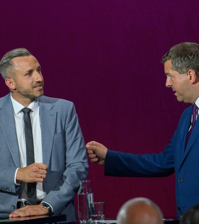 Ulrich Siegmund (l, AfD) und Sven Schulze (CDU), Ministerpräsident von Sachsen-Anhalt, im Gespräch bei der MDR-Wahlarena.
