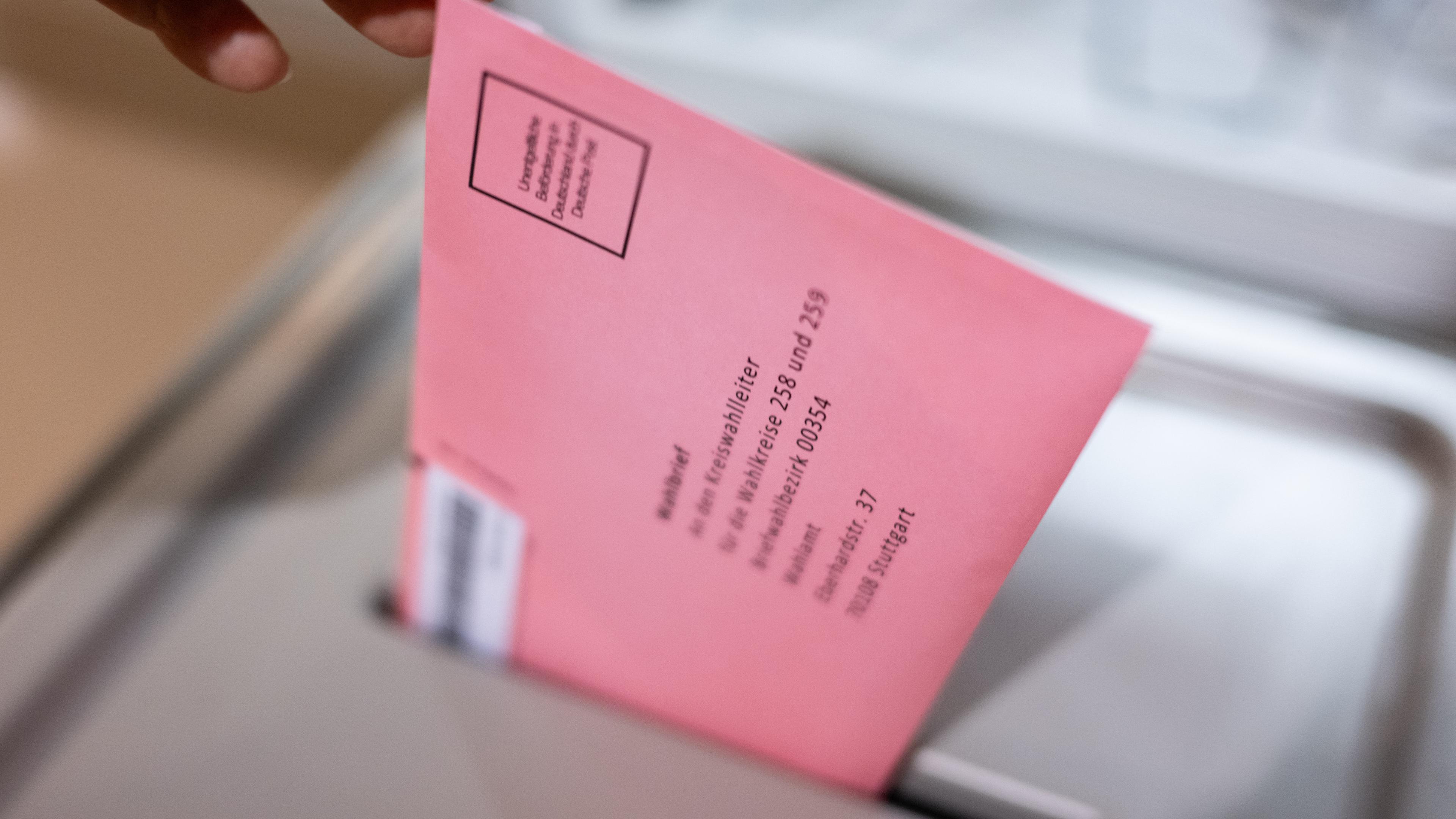 Wahlbrief wird in Urne gesteckt