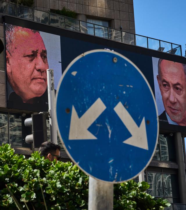 ARCHIV - 23.09.2026, Israel, Ramat Gan: Ein Mann geht an einer Werbung vorbei, auf der der israelische Ministerpräsident Benjamin Netanjahu (r) und sein Hauptkonkurrent, der Oppositionskandidat Gadi Eisenkot, im Vorfeld der Parlamentswahlen in Israel zu sehen sind. Am 27. Oktober soll ein neues israelisches Parlament gewählt werden. 