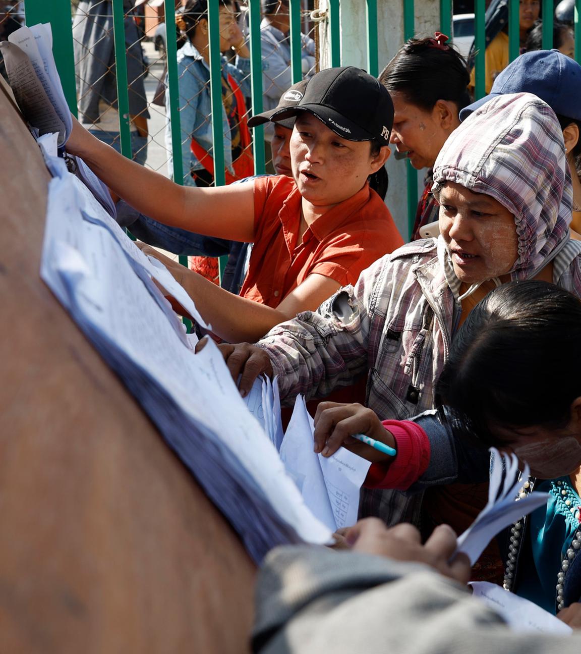 Wählerinnen und Wähler in Myanmar überprüfen während der ersten Phase der Parlamentswahl die Wählerlisten in einem Wahllokal in Naypyitaw, Myanmar, am 28. Dezember 2025.