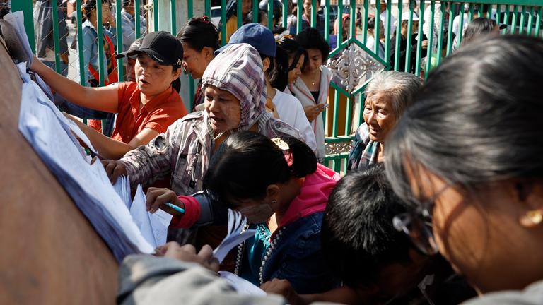 Wählerinnen und Wähler in Myanmar überprüfen während der ersten Phase der Parlamentswahl die Wählerlisten in einem Wahllokal in Naypyitaw, Myanmar, am 28. Dezember 2025.