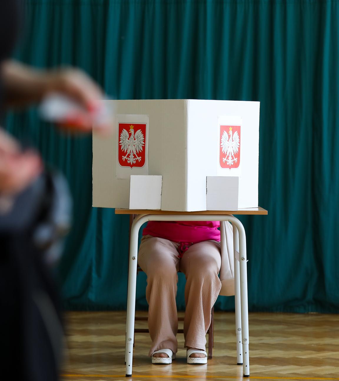 Eine Frau sitzt in einem Wahllokal und füllt ihre Wahlunterlagen aus während der Stichwahl bei den Präsidentschaftswahlen in Krakau, Polen, am 1. Juni 2025. 