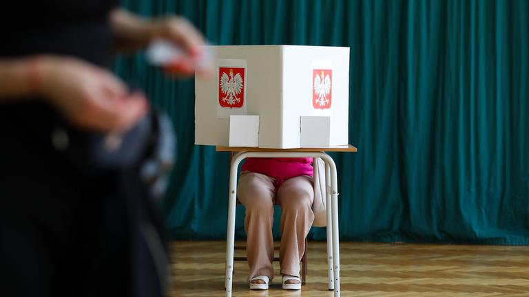 Eine Frau sitzt in einem Wahllokal und füllt ihre Wahlunterlagen aus während der Stichwahl bei den Präsidentschaftswahlen in Krakau, Polen, am 1. Juni 2025. 