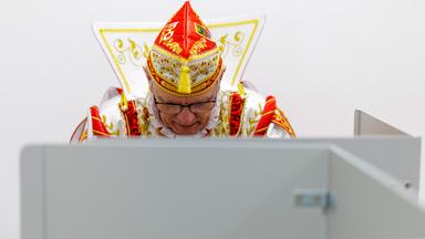 Karnevalist in einer Wahlkabine