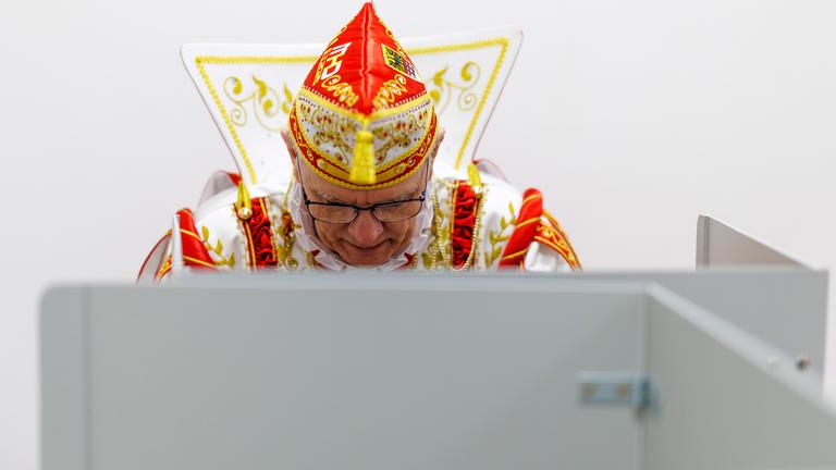 Karnevalist in einer Wahlkabine