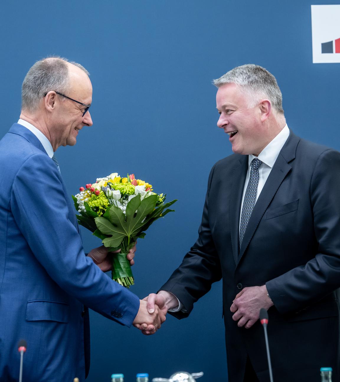 Gordon Schnieder (CDU) erhält Blumen von Bundeskanzler Friedrich Merz.