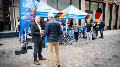 Leif-Erik Holm, AfD-Ministerpräsidentenkandidat für die kommende Landtagswahl, spricht mit einem Bürger am Schweriner Marienplatz.