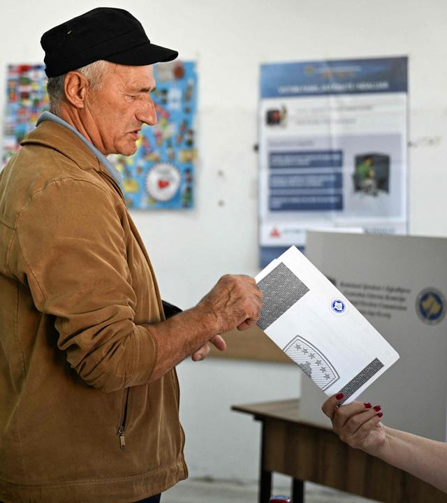 Ein Wähler erhält am Tag der Parlamentswahlen in einem Wahllokal seinen Stimmzettel am 07.06.2026 in Pristina, Kosovo,