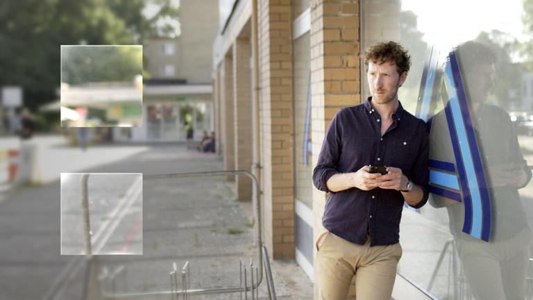 Der Moderator Louis Klamroth lehn an einem Schaufenster einer Discounter-Filiale