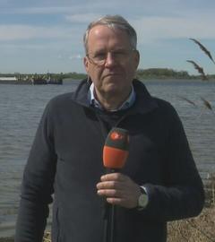 ZDF-Reporter Mosebach am Strand. Im Hintergrund ist der Frachtkahn der Rettungsaktion auf dem Wasser zu sehen.