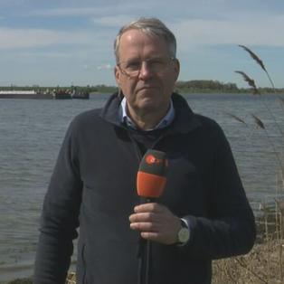 ZDF-Reporter Mosebach am Strand. Im Hintergrund ist der Frachtkahn der Rettungsaktion auf dem Wasser zu sehen.