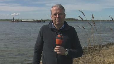 ZDF-Reporter Mosebach am Strand. Im Hintergrund ist der Frachtkahn der Rettungsaktion auf dem Wasser zu sehen.