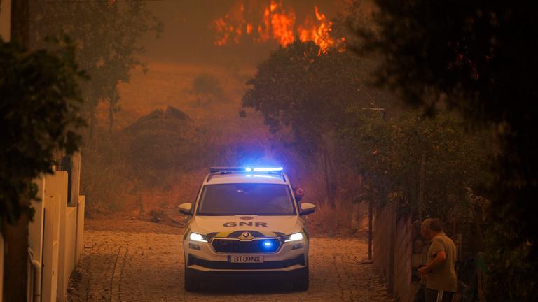 Ein Auto der Nationalen Republikanischen Garde (GNR) fährt während eines Waldbrandes vorbei, der in Valpacos begann und jetzt in den Dörfern Fradizela, Gemeinde Mirandela, Portugal, wütet, 29. Juli 2026. 