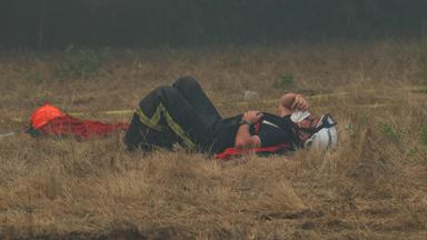 Ein Feuerwehrmann ruht sich am 29. Juli 2026 inmitten der Löscharbeiten bei einem Waldbrand nahe Lanton im Südwesten Frankreichs auf dem ausgetrockneten Gras aus. 