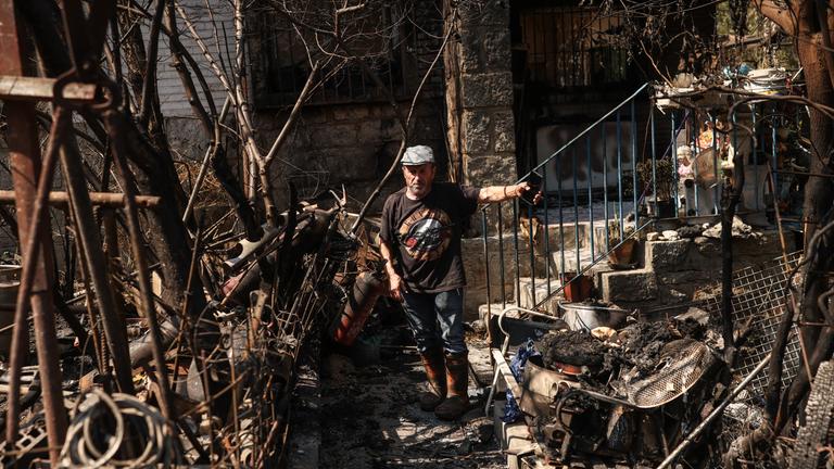  Ein Anwohner steht vor seinem Haus, das durch den Waldbrand vollständig niedergebrannt ist