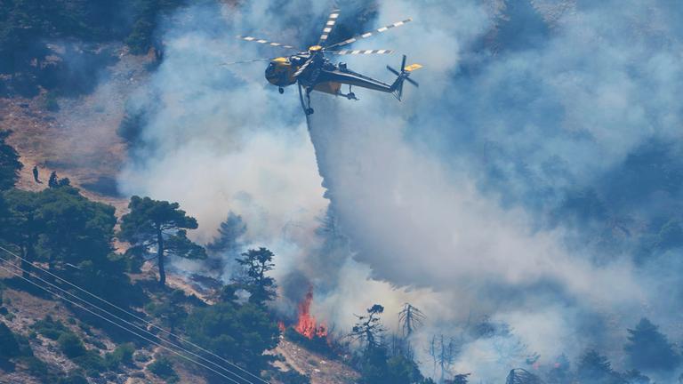 Ein Löschhubschrauber wirft Wasser über einen Waldbrand auf dem Berg Kithairon in der Nähe von Porto Germeno nordwestlich von Athen ab.