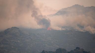 Spanien: Mijares: Ein Wald durch einen Waldbrand von Rauch und Flammen umgeben. 