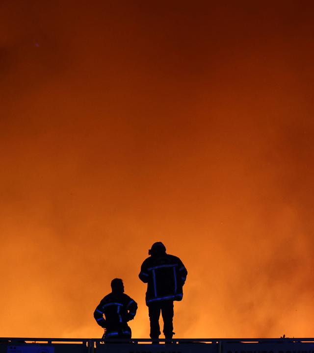 Feuerwehrleute beobachten am 22. 7. 2026 einen Waldbrand in Le Porge im Südwesten Frankreichs.