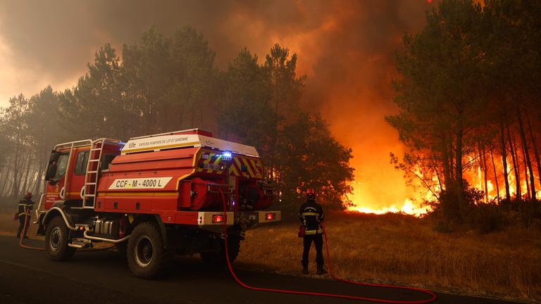 Feuerwehrleute versuchen in der Nähe von Le Porge im Südwesten Frankreichs mit einem Waldbrandlöschfahrzeug, die brennenden Bäume zu löschen.