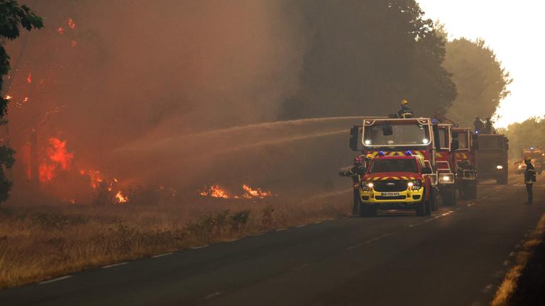 Feuerwehrleute versuchen, mit Tanklöschfahrzeugen einen Waldbrand nahe Le Porge im Südwesten Frankreichs zu bekämpfen.