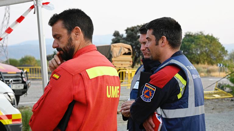 Deutsche (r) und spanische Feuerwehrmänner stehen zur Einsatzbesprechung in der Provinz Caceres zusammen. 